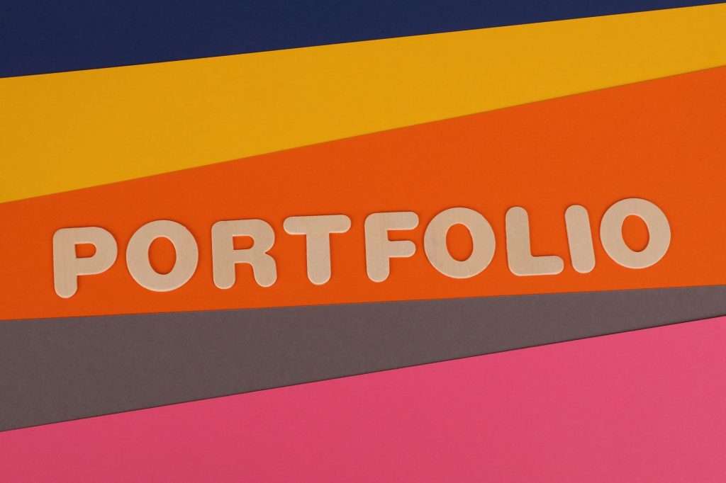 A vibrant multicolored background featuring the text 'PORTFOLIO' in pink font on colorful paper.