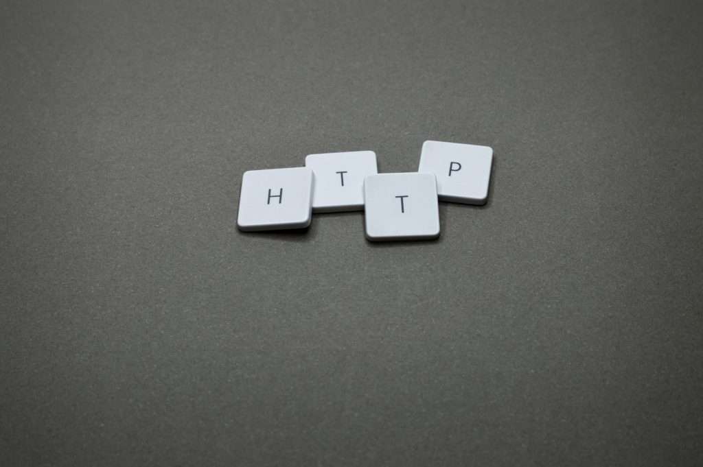 High-angle photo of keyboard tiles spelling HTTP on a dark background.