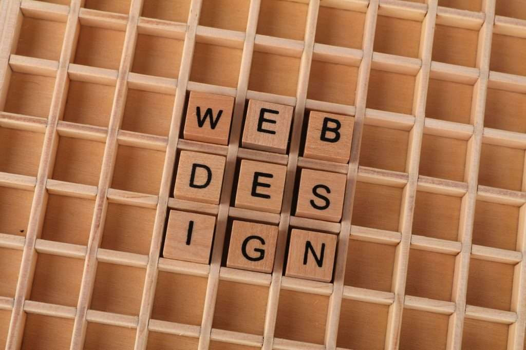 Wooden blocks spelling web design on a grid background symbolizing creative digital design concepts.