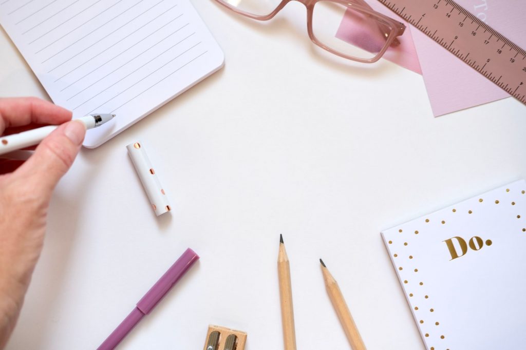 Aesthetic flat lay of pink and gold stationery essentials for creative workspaces.