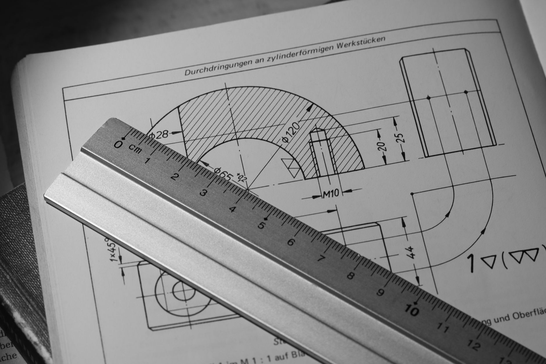 Black and white image of technical drawing with metal ruler, ideal for engineering concepts.