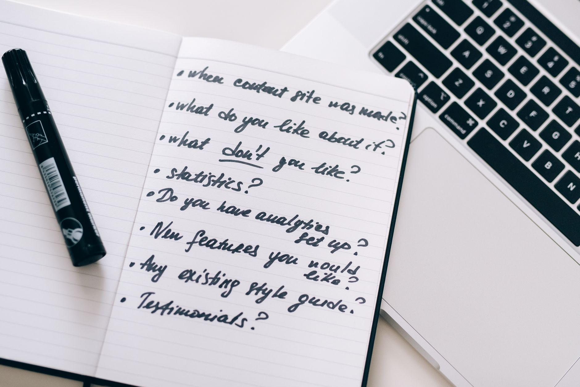 Close-up of a notebook with handwritten notes next to a laptop, ideal for business or educational content.