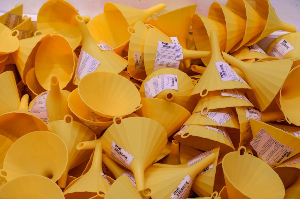 Close-up of a pile of yellow plastic funnels for sale in an Istanbul market.