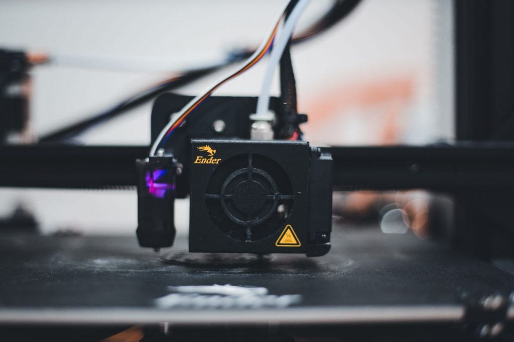 Detailed view of a 3D printer nozzle during the printing process, showcasing advanced technology.