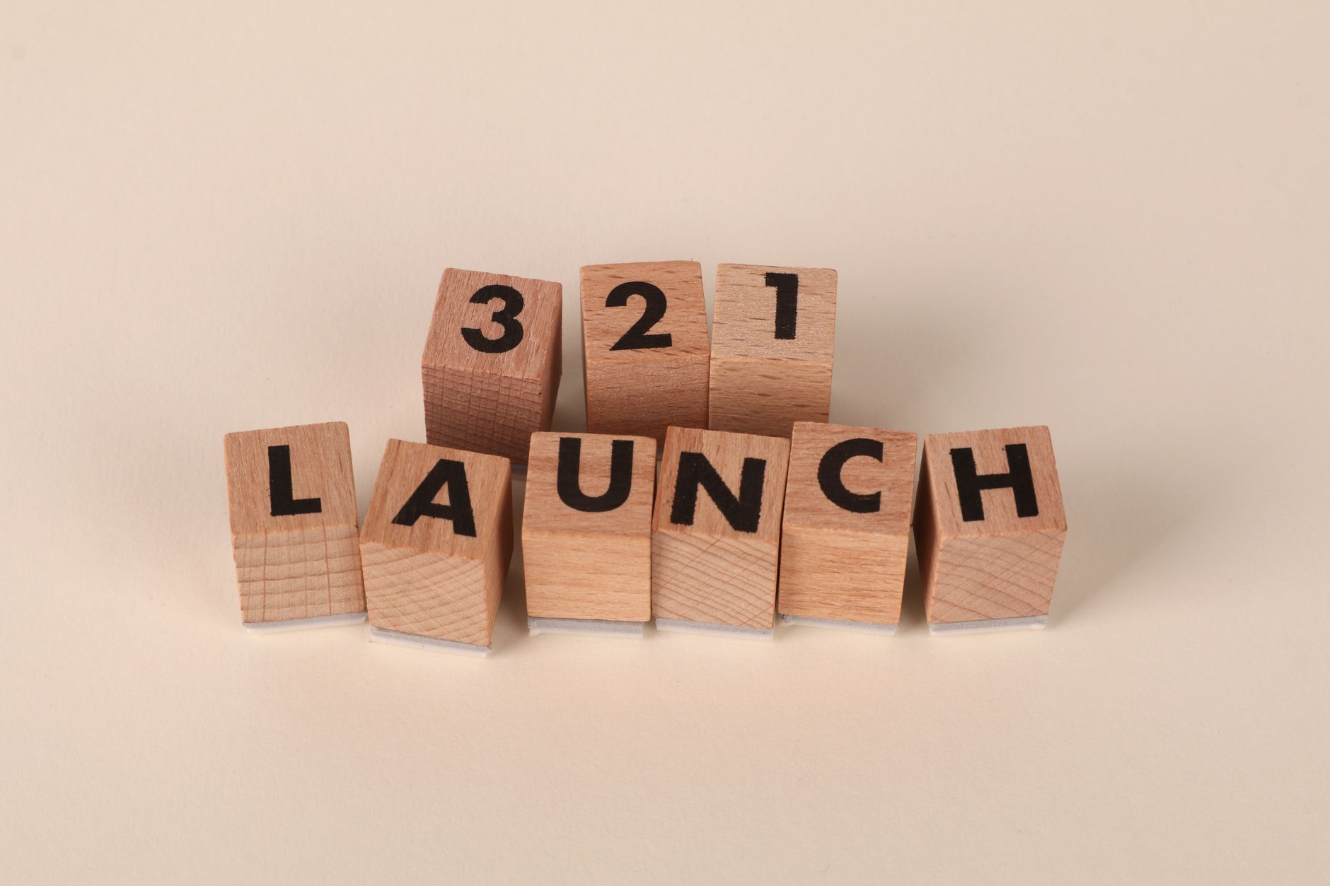 Wooden blocks arranged to spell '3, 2, 1 Launch' symbolizing a countdown.